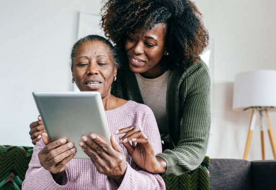Woman being assisted in using an ipad or tablet